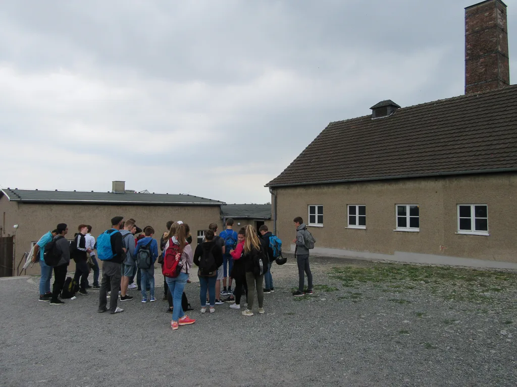 Gruppe steht auf dem Appellplatz vor den Gebäuden der Gedenkstätte.